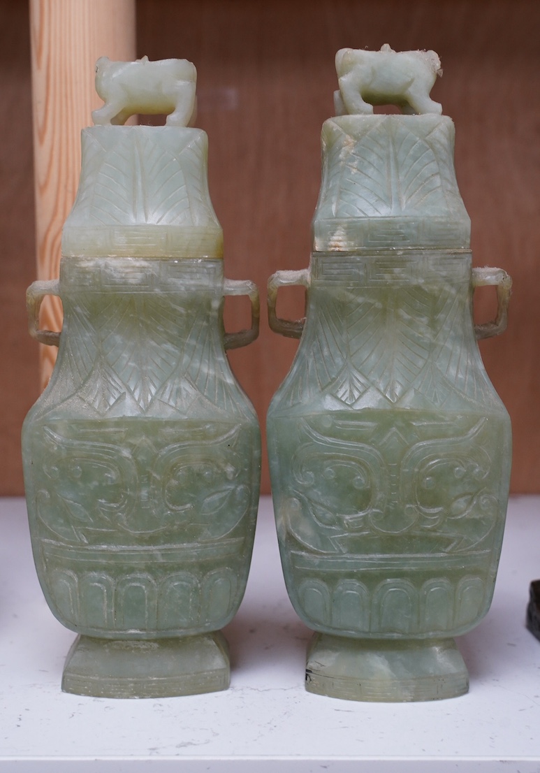 A pair of Chinese carved green quartz vases and covers, 21cm. Condition - fair, natural crack to body of one vase, chips to edges of both